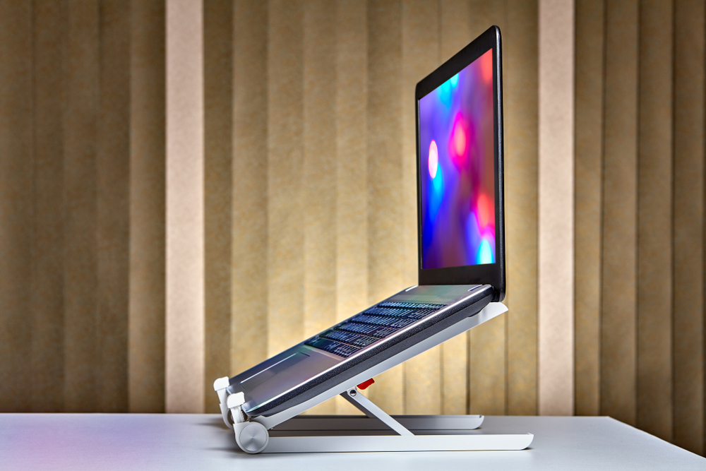 A laptop on a stand with a vibrant screen displaying various colors.